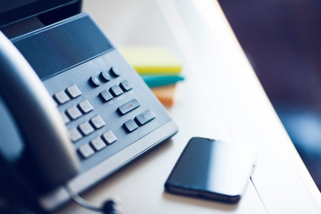 Ip telephony concept. Modern ip phones, sip terminals, conference phones and cameras for video meetings on office background. Top view.