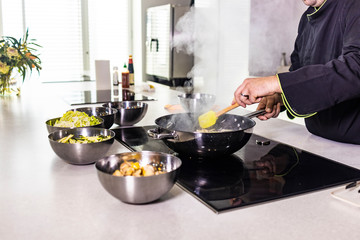 Chef cooking fresh vegetables  on a wok