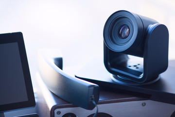 Ip telephony concept. Modern ip phones, sip terminals, conference phones and cameras for video meetings on office background. Top view.