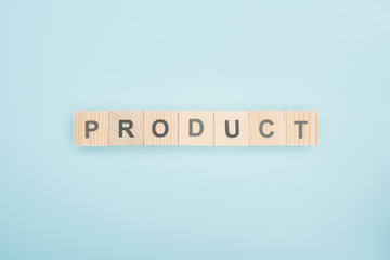 top view of product lettering made of wooden cubes on blue background