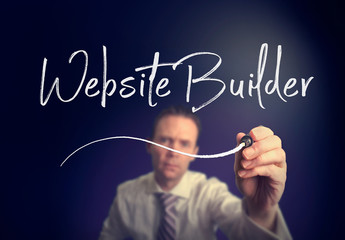 A businessman writing a Website Builder concept with a white pen on a clear screen.