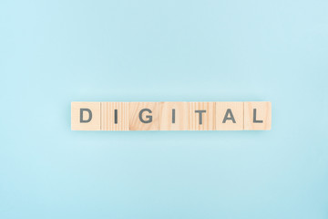 top view of digital lettering made of wooden cubes on blue background