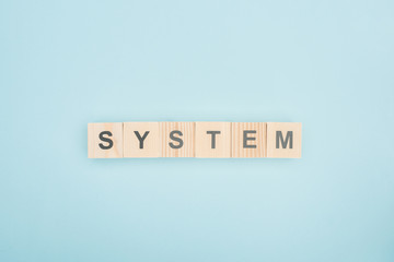 top view of system lettering made of wooden cubes on blue background