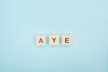 top view of aye lettering made of wooden cubes on blue background