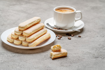 Italian Savoiardi ladyfingers Biscuits and cup of coffee on concrete backgound