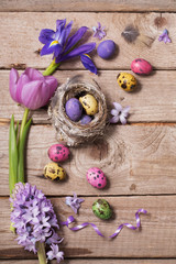Easter eggs with spring flowers on wooden background