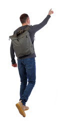 Back view of a walking man with a bag pointing his hand up.