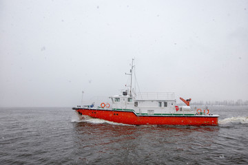 Test the motor boat on the Kama River in the late fall in snowfall