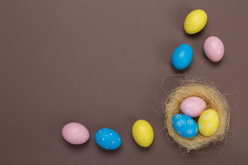 Fototapeta na wymiar Colorfull easter eggs in nest on pastel color background with space. Concept