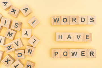 top view of phrase words have power lettering with wooden cubes on yellow background