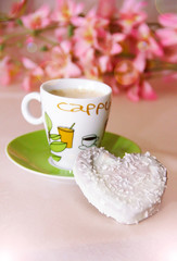 white sweet heart-shaped cookies and a cup of coffee on a green plate