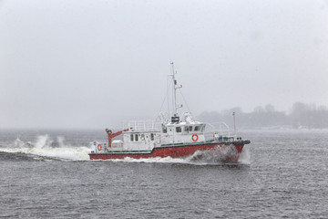 Test the motor boat on the Kama River in the late fall in snowfall