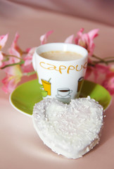 white sweet heart-shaped cookies and a cup of coffee on a green plate