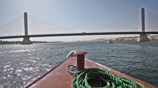 Sailing towards large cable stayed road bridge spanning wide Nile river on a clear day in Egypt