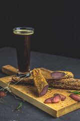 Dark beer in glass and Jerky, basturma, dried meat beef