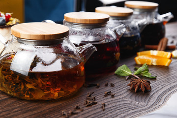 various teas in teapots on a wooden table. selective focus