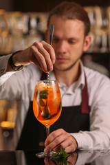 Barmen is making Aperol Spritz cocktail.  Alcohol cocktail on black background surface