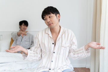 Gay couple having argument and do not take care each other in bedroom at home. Homo sexsual love concept.