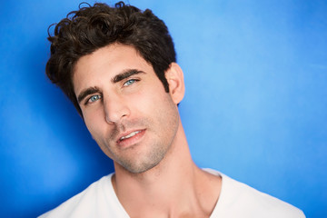Portrait of young guy on blue background