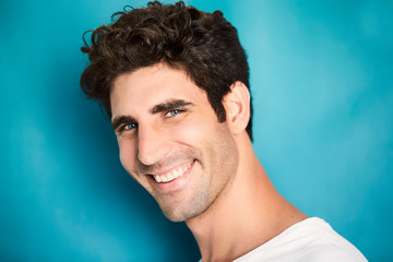 Smiling guy in studio against blue background