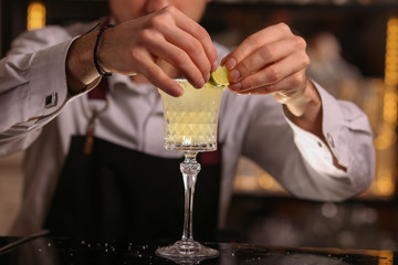 Margarita alcohol cocktail with lime ice. Alcohol cocktail on black background surface.  Barmen is making Margarita