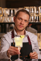 Margarita alcohol cocktail with lime ice. Alcohol cocktail on black background surface.  Barmen is making Margarita