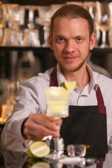 Margarita alcohol cocktail with lime ice. Alcohol cocktail on black background surface.  Barmen is making Margarita
