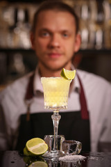 Margarita alcohol cocktail with lime ice. Alcohol cocktail on black background surface.  Barmen is making Margarita