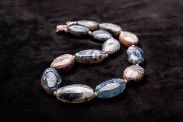 Marble stones with weaving on a black velvet background