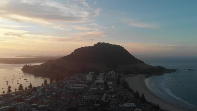 4k aerial mout manganui sunset camer dolly back