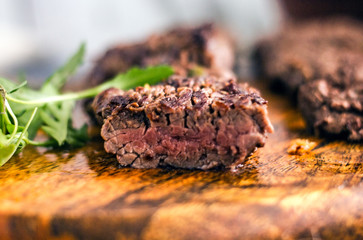 Beef Machete Steak. Grilled steak on a wooden board on a dark background. Delicious grilled meat, medium steak grilled, roast beef pieces.  Machete steaks of medium roast on a wooden board