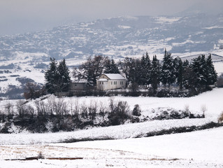 Little white chapel in a cemetery, in snow covered field. Beautiful scenery with a small church in snow.