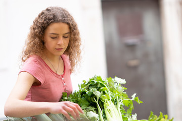 Young woman shopping for vegetables and fruit at the market