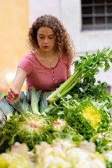 Young woman shopping for vegetables and fruit at the market