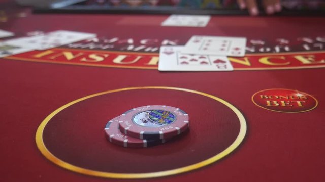 Unidentifiable dealer dealing cards in a blackjack table, also known as 21 in a casino
