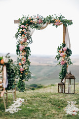 Italian wedding decoration. Green eucalyptus, oranges and pink flowers decorate wedding altar