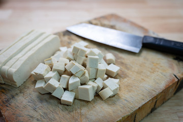 tofu, bean curd, soybean cake on chopping wood