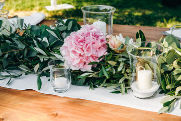 Floral garland of eucalyptus lies on the wedding dinner table