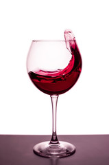 splashes of red wine in a wineglass