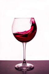 splashes of red wine in a wineglass