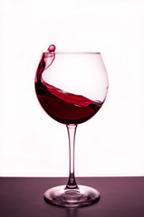 splashes of red wine in a wineglass