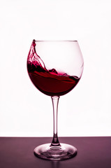 splashes of red wine in a wineglass