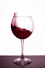 splashes of red wine in a wineglass