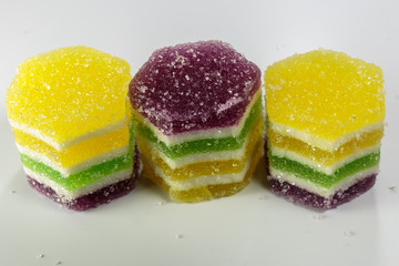 Colorful multilayer marmalade on white background, ready for eat. Closeup of dessert for business lunch.
