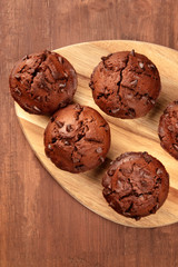 Chocolate muffins, shot from above on a dark rustic wooden background with a place for text