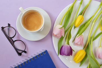 Cup of coffee and tulips on table