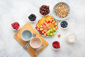 Raw vegan gluten and grain free paleo granola or muesli made from nuts. Fruit berries platter,...