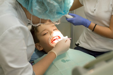 Orthodontist examining boy mouth