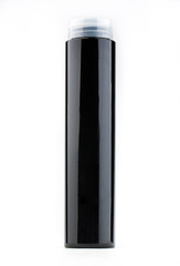 A glossy black bottle with a white cover from under shampoo