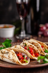Concept of Mexican cuisine. Mexican appetizer Tacos with vegetables, beans, paprika, chilli peppers on fried unleavened bread cakes. Taco for veterinarians. Background image.